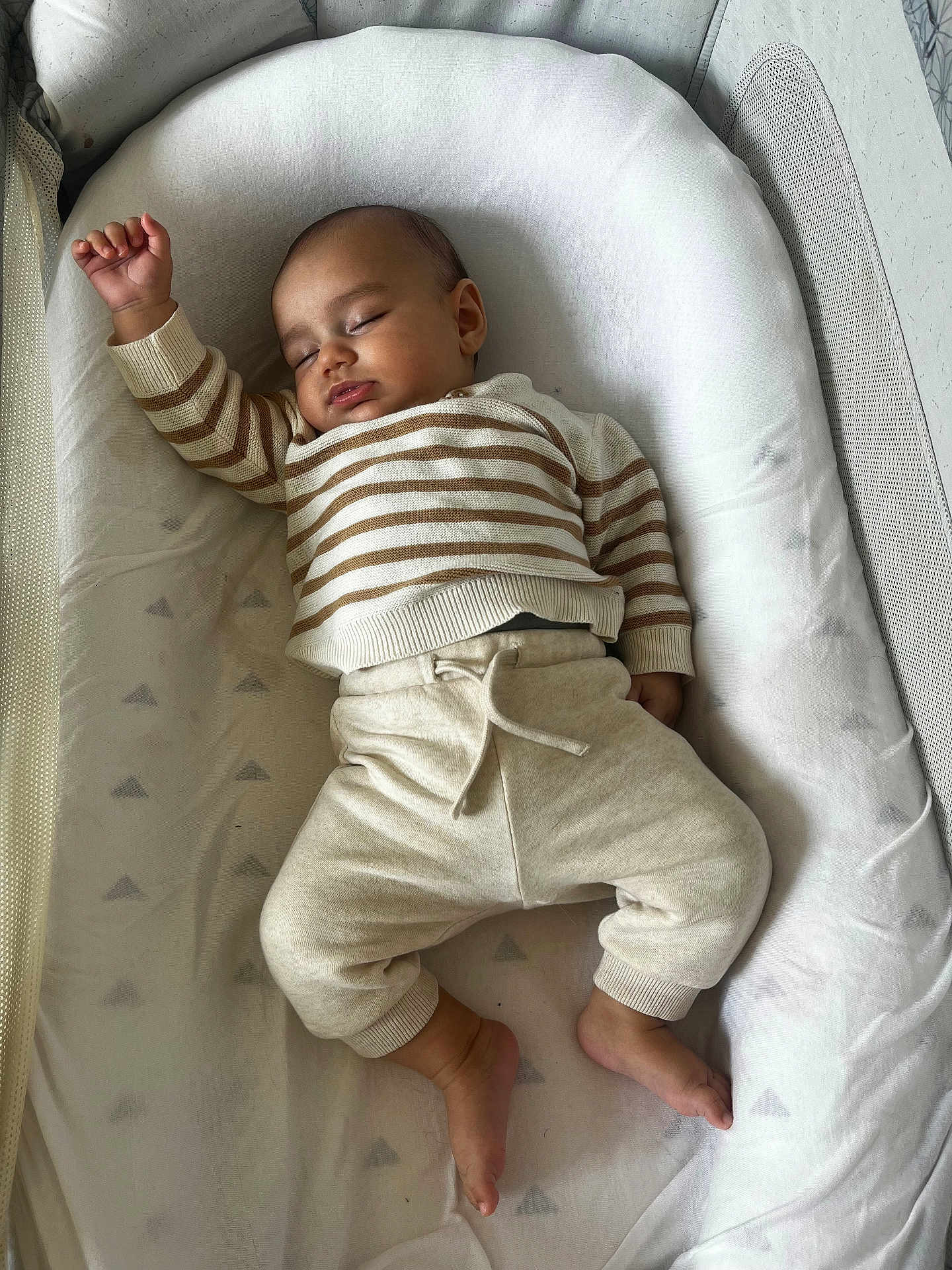 Ethan participe au concours pour gagner de l'argent avec cette photo : baby, sleeping, infant, striped_clothing, cozy, soft_bedding, peaceful, child, cute, relaxed, pajamas, white, cushion, indoors, young_child, resting, comfort, small_feet, raised_arm, portrait