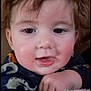 Samuel is registered to the contest to win money with this photo: baby, child, face, closeup, smile, hair, blanket, hand, indoor, cozy, cute, infant, portrait, toddler, clothing, wooden_wall, warm_colors, expression, skin, person