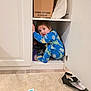 toddler, child, pajamas, cabinet, kitchen, curious, playful, box, detergent, floor, rug, toy, hiding, curiosity, indoor, person, clothing, door, peek, mischief