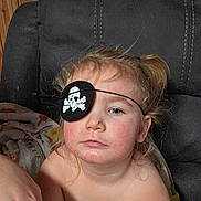 Zamara joined the competition — help win amazing prizes! blanket, blond_hair, casual, chair, child, cozy, expressionless, eye_patch, face, hair, home, indoor, person, pirate, portrait, relaxed, seated, skin, toddler, young_child