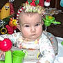 Zamara is registered to the contest to win money with this photo: baby, infant, holiday_hat, toy, activity_center, indoor, child, face, expressionless, clothing, seat, colorful, plaything, headwear, wood_paneling, couch, background, person, serious, young