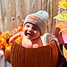baby, pumpkin, beanie, smiling, fall, autumn, wooden_background, orange, cute, child, hat, sunlight, decor, festive, happy, portrait, skin, foot, seasonal, outdoor