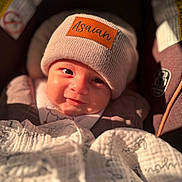 Asaiah joined the competition — help win amazing prizes! baby, child, smile, hat, knit_hat, blanket, car_seat, closeup, face, infant, warm_clothing, cozy, sunlight, portrait, cute, indoors, soft_texture, happy, young_child, comfort