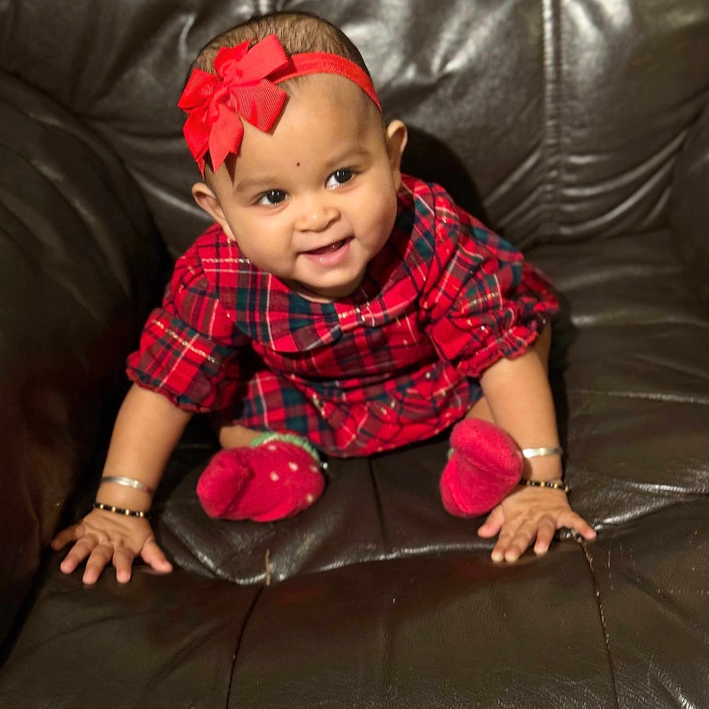 Jisha joined the competition — help win amazing prizes! adorable, baby, bracelets, brown_couch, child, cute, furniture, happy, headband, indoors, infant, leather_couch, person, plaid_dress, portrait, red_bow, red_socks, sitting, smiling, young_child