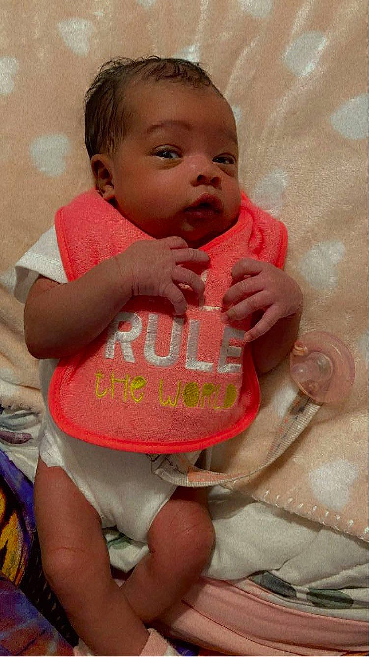 Ellianna is registered to the contest to win money with this photo: baby, baby_toddler_clothing, chair, cheek, face, finger, happy, head, human_body, joint, leg, lip, mouth, neck, person, pink, shoulder, skin, stomach, textile