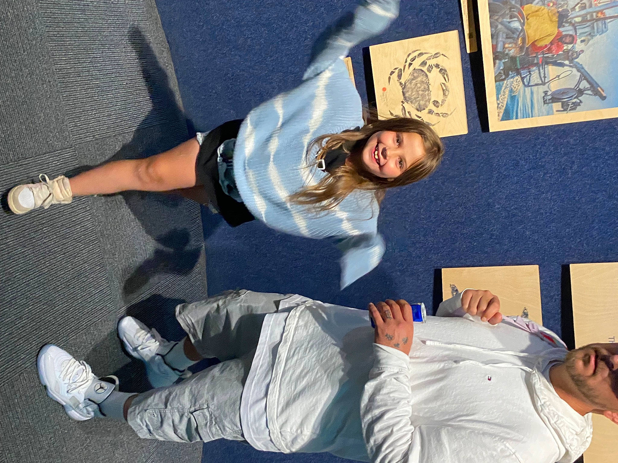 Peyton is registered to the contest to win money with this photo: arm, art, comfort, denim, foot, fun, human_leg, joy, knee, leg, leisure, person, room, sitting, smile, sneakers, sock, sportswear, t_shirt, thigh