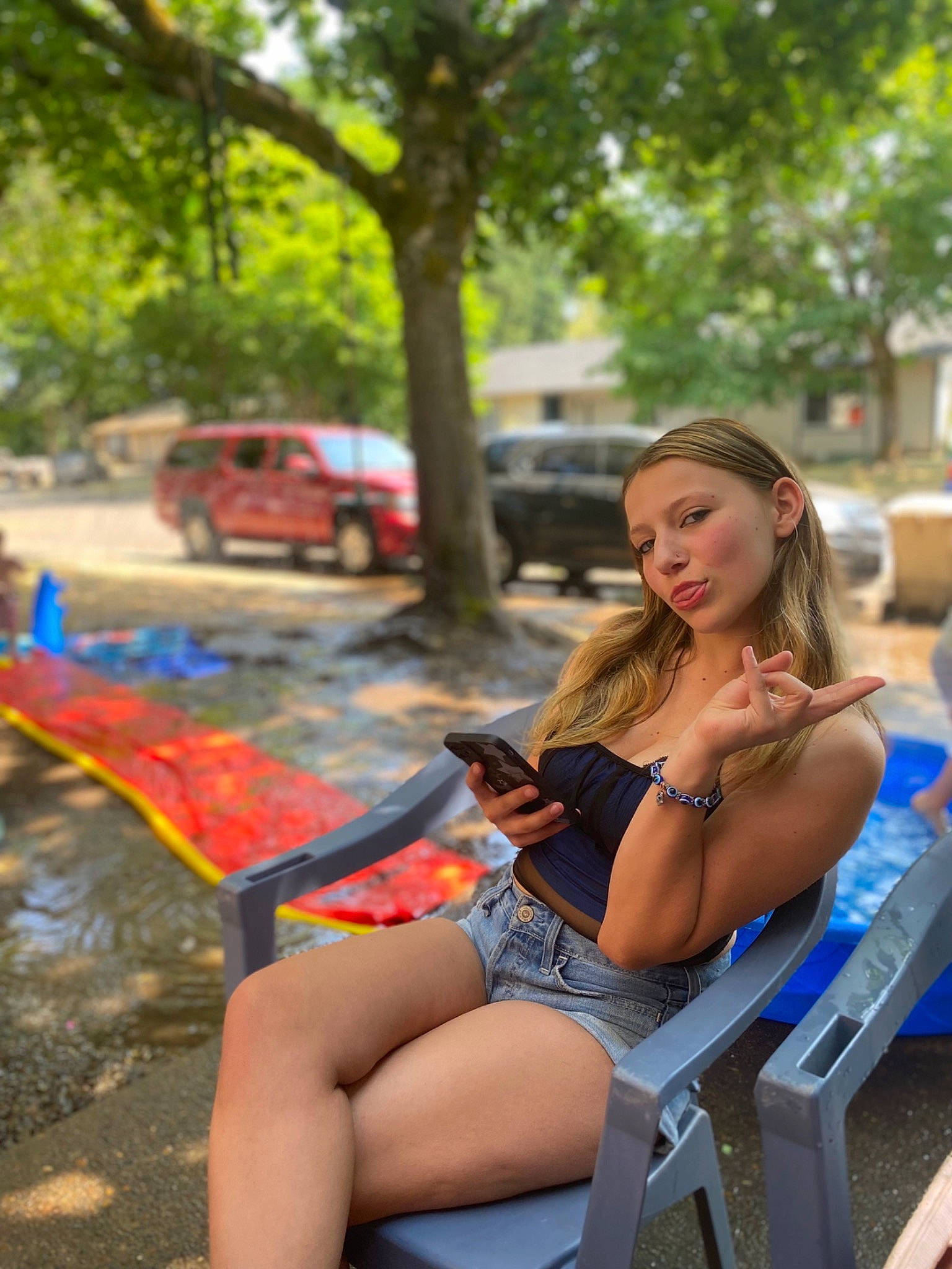 Madison joined the competition — help win amazing prizes! automotive_design, blond, brown_hair, car, electric_blue, eyewear, fun, grass, human_leg, knee, leisure, long_hair, orange, person, recreation, shorts, sitting, thigh, tints_and_shades, tree