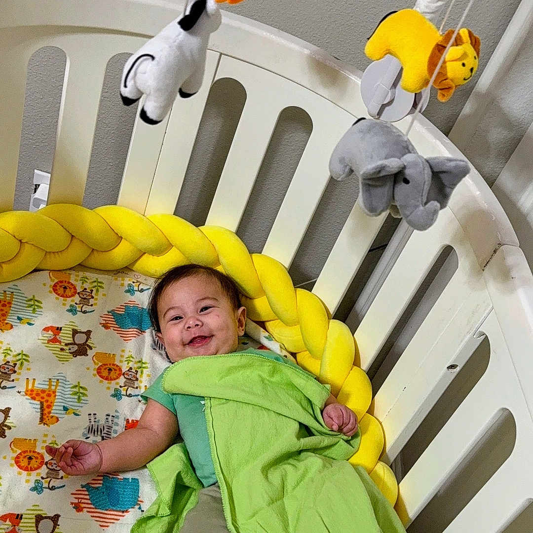 Patrick joined the competition — help win amazing prizes! animal_print, baby, bedding, bedroom, blanket, child, crib, cute, furniture, green, happy, indoor, infant, mobile, playful, resting, smiling, stuffed_animals, toddler, yellow