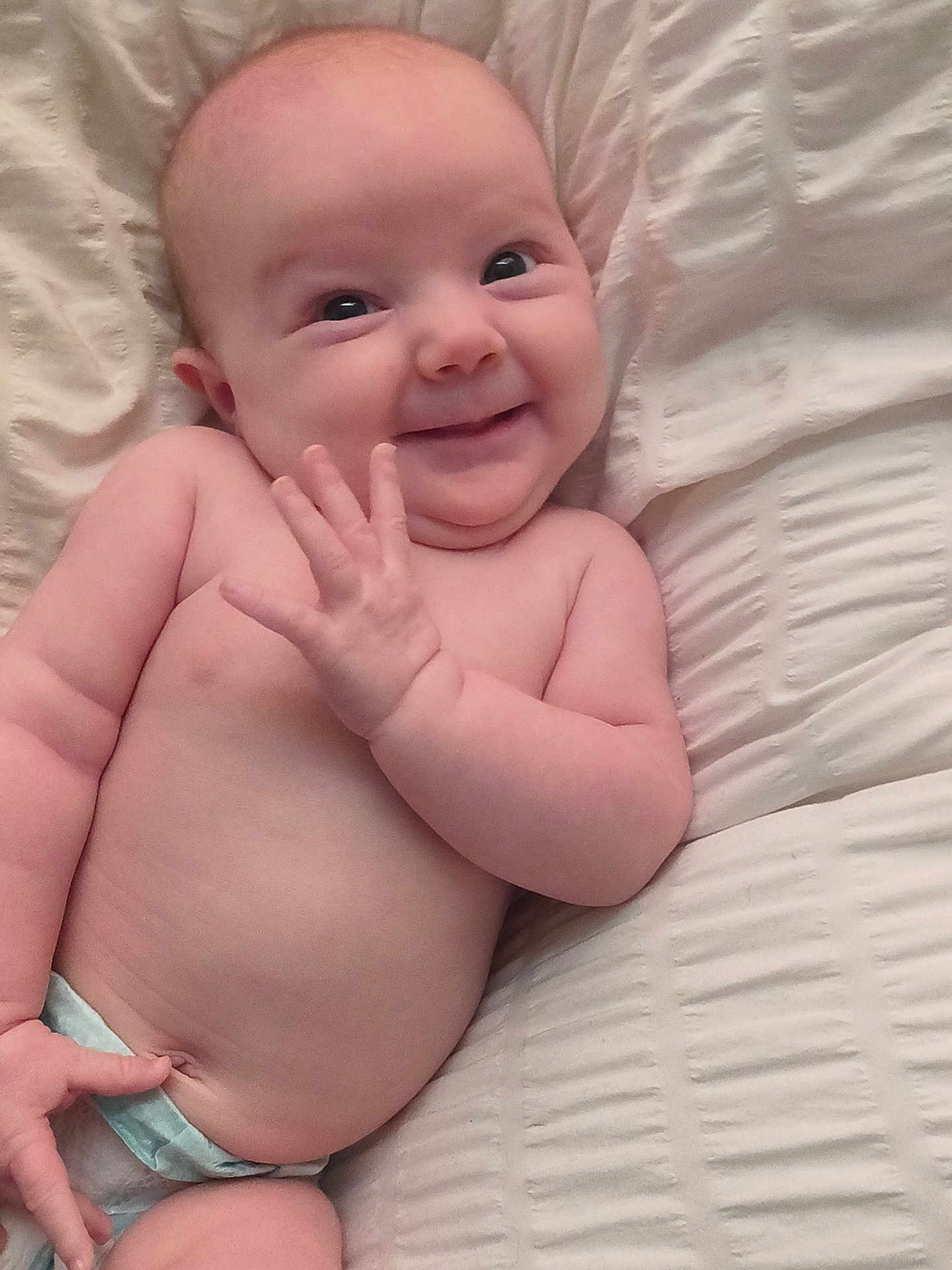 Evera joined the competition — help win amazing prizes! baby, infant, smile, hand, diaper, skin, face, cheeks, cute, lying_down, expression, child, newborn, pale_skin, blanket, young, happy, cute_face, small_hands, playful