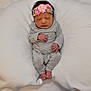 Rosie is registered to the contest to win money with this photo: newborn, baby, sleeping, headband, flower, pink, grey_clothing, pajamas, blanket, white, soft, cozy, infant, peaceful, cute, small_feet, hands, portrait, resting, child