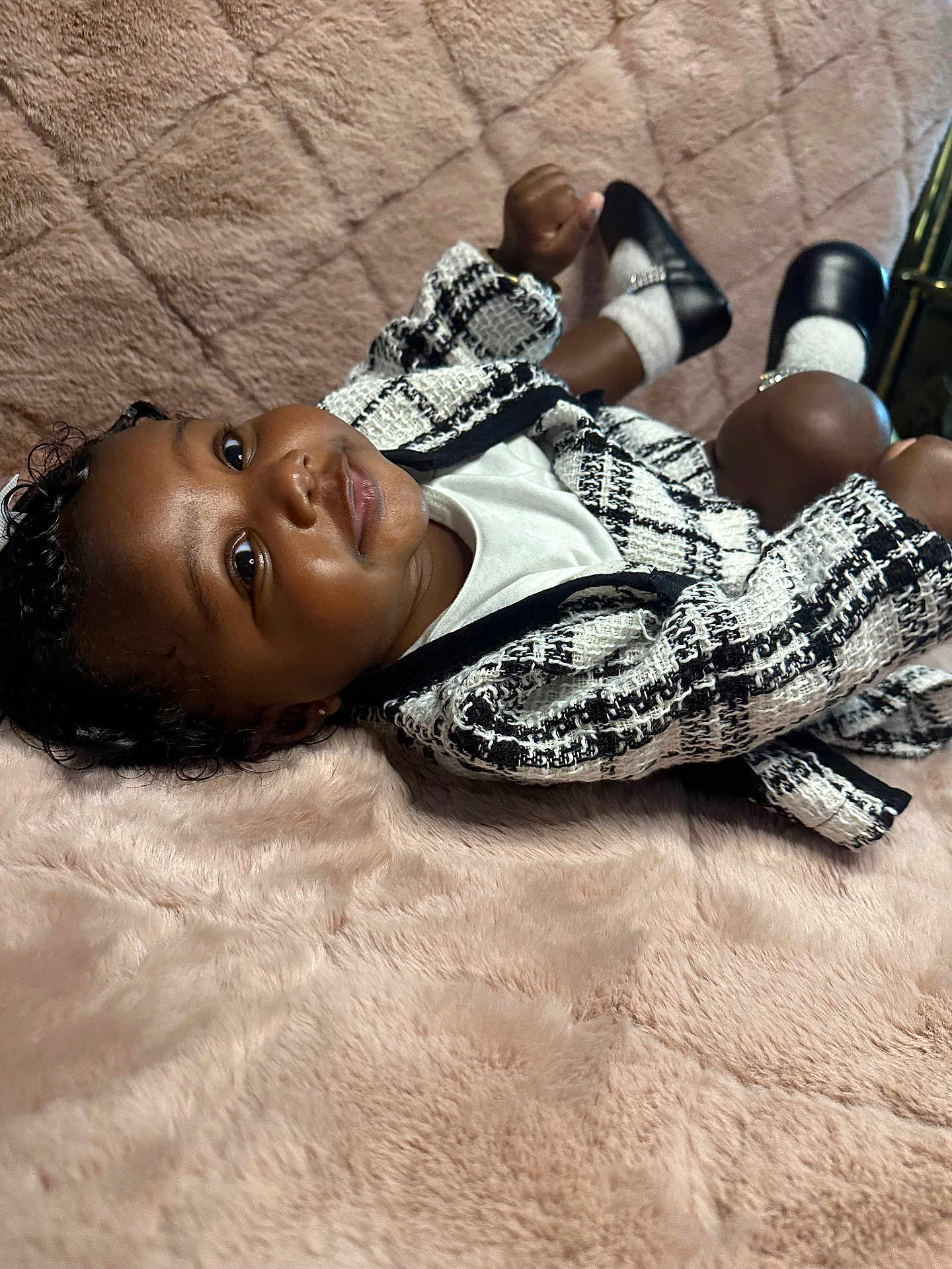 Khaloni joined the competition — help win amazing prizes! baby, child, infant, black_and_white_jacket, shoes, socks, blanket, plush, soft_texture, portrait, cute, smiling, indoor, fashion, clothing, person, face, head, relaxing, lying_down