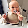 Kody is registered to the contest to win money with this photo: baby, child, high_chair, bib, spoon, food, yogurt, face, mouth, hand, smile, indoor, window, feeding, person, cute, happy, infant, cheeks, clothing