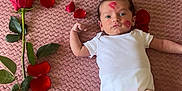 Seyyed participe au concours pour gagner de l'argent avec cette photo : baby, infant, newborn, person, face, eyes, onesie, white_clothing, rose, rose_petals, petals, pink_blanket, blanket, kiss_mark, lipstick, lying_down, arm, legs, romantic, soft_texture