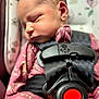 Stella is registered to the contest to win money with this photo: baby, car_seat, child, close_up, cute, face, floral_pattern, harness, head, indoors, infant, newborn, peaceful, pink_clothing, portrait, resting, safety, seatbelt, sleeping, small