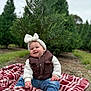 baby, child, smile, outdoor, pine_tree, blanket, headband, fleece_jacket, vest, jeans, sneakers, grass, nature, holiday, seasonal, greenery, cute, happy, portrait, sitting