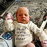Lillian is registered to the contest to win money with this photo: baby, infant, child, portrait, lying_down, bouncer, onesie, mittens, pink_clothing, white_clothing, face, expression, indoors, living_room, rug, baby_gear, stitch_character, text_on_clothing, funny, cozy