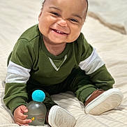 Alexander joined the competition — help win amazing prizes! baby, bed, bottle, child, cozy, cute, face, footwear, green_clothing, hand, happy, indoors, infant, portrait, shoes, sitting, skin, smiling, toy, young_child