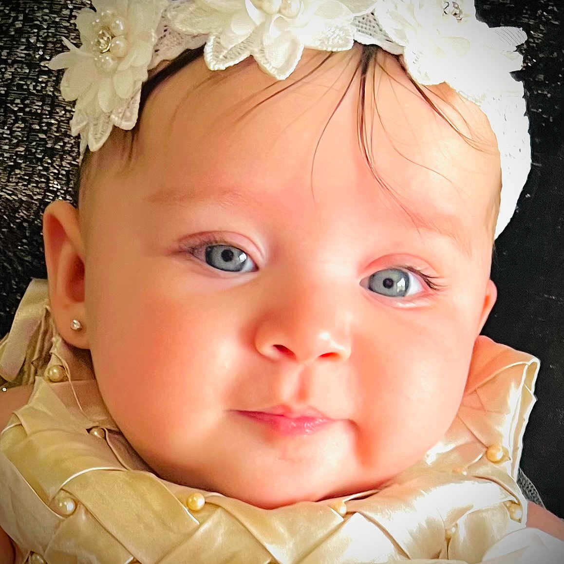 Liz Angeli is registered to the contest to win money with this photo: adorable, baby, background, blue_eyes, child, closeup, cute, earring, eyelashes, face, fashion, flowers, golden_outfit, headband, infant, lace, pearl, portrait, skin, texture
