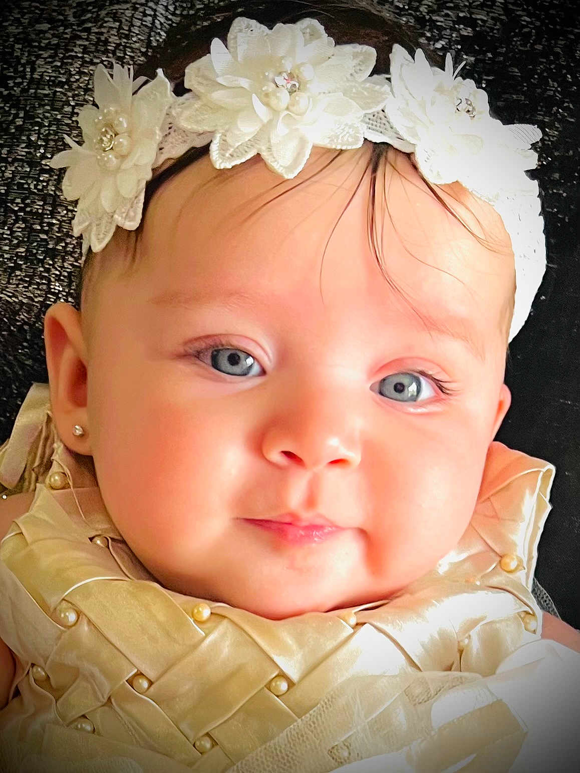 Liz Angeli is registered to the contest to win money with this photo: baby, child, portrait, headband, flowers, blue_eyes, pearl, lace, golden_outfit, closeup, cute, infant, face, skin, eyelashes, earring, fashion, texture, background, adorable