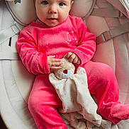 Léna participe au concours pour gagner de l'argent avec cette photo : baby, infant, pink_onesie, teddy_bear, baby_seat, plush_toy, cushion, soft_toy, floor, wooden_floor, face, hands, footed_pajamas, indoor, cute, child, person, expression, looking_up, comfort