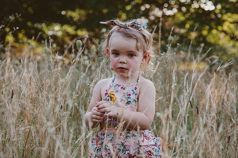 Emilia is registered to the contest to win money with this photo: baby_toddler_clothing, blond, brown_hair, child, dress, eyewear, flash_photography, fun, grass, grass_family, grassland, happy, iris, meadow, people_in_nature, person, plant, prairie, smile, summer