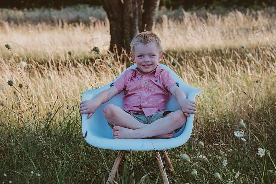 Greyson joined the competition — help win amazing prizes! chair, child, dress, eye, flash_photography, fun, grass, grassland, happy, joy, leisure, meadow, natural_environment, people_in_nature, person, plant, recreation, smile, t_shirt, toddler