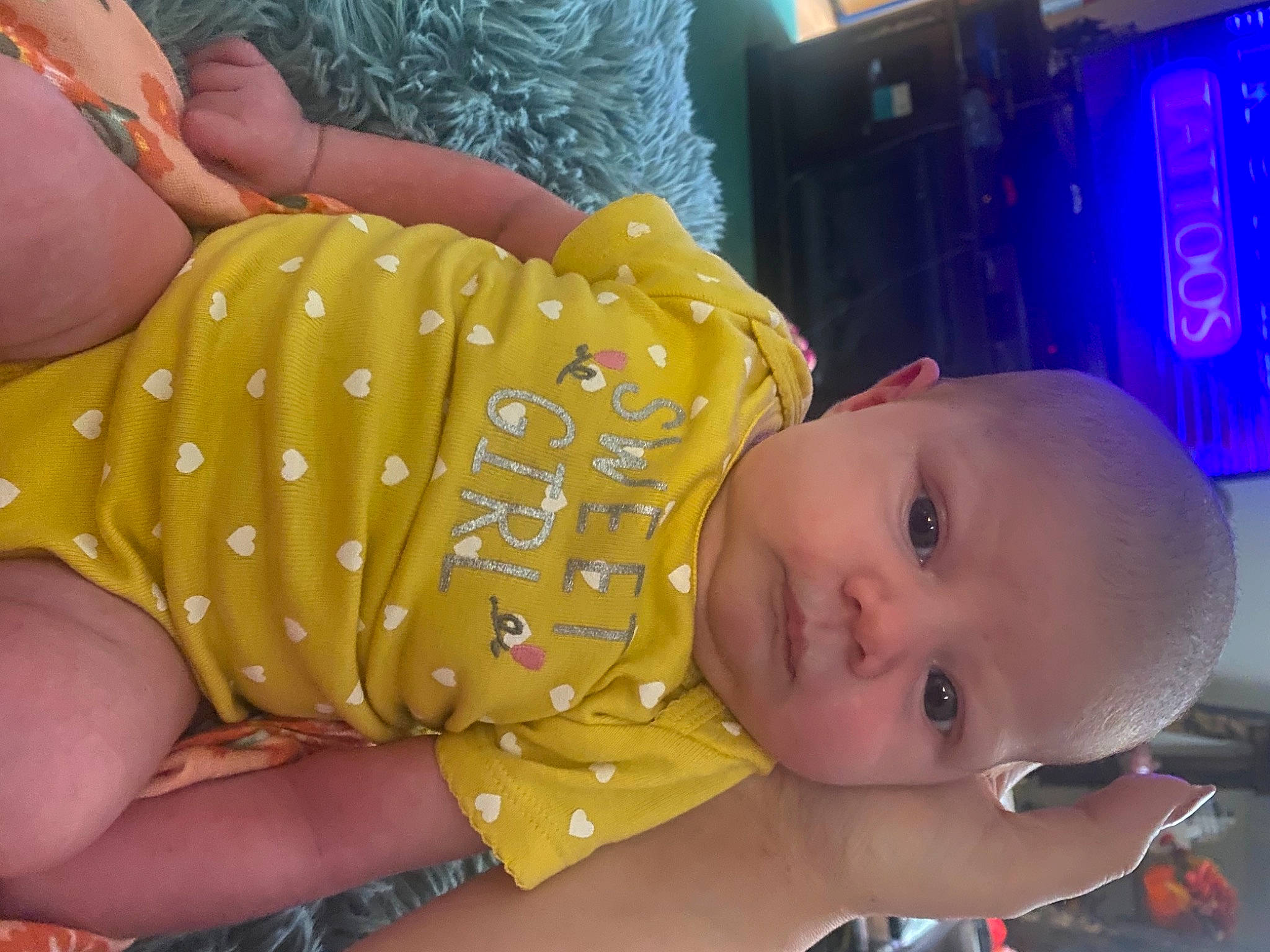Alexandria is registered to the contest to win money with this photo: baby, baby_products, baby_toddler_clothing, cheek, child, finger, fun, glasses, hand, happy, human_leg, mouth, nose, orange, pattern, person, skin, smile, thigh, thumb