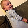 Ivan joined the competition — help win amazing prizes! baby, child, smiling, onesie, toy, couch, indoor, happy, face, hand, furniture, person, infant, young_child, baby_clothing, playful, cute, leaning, bright, portrait