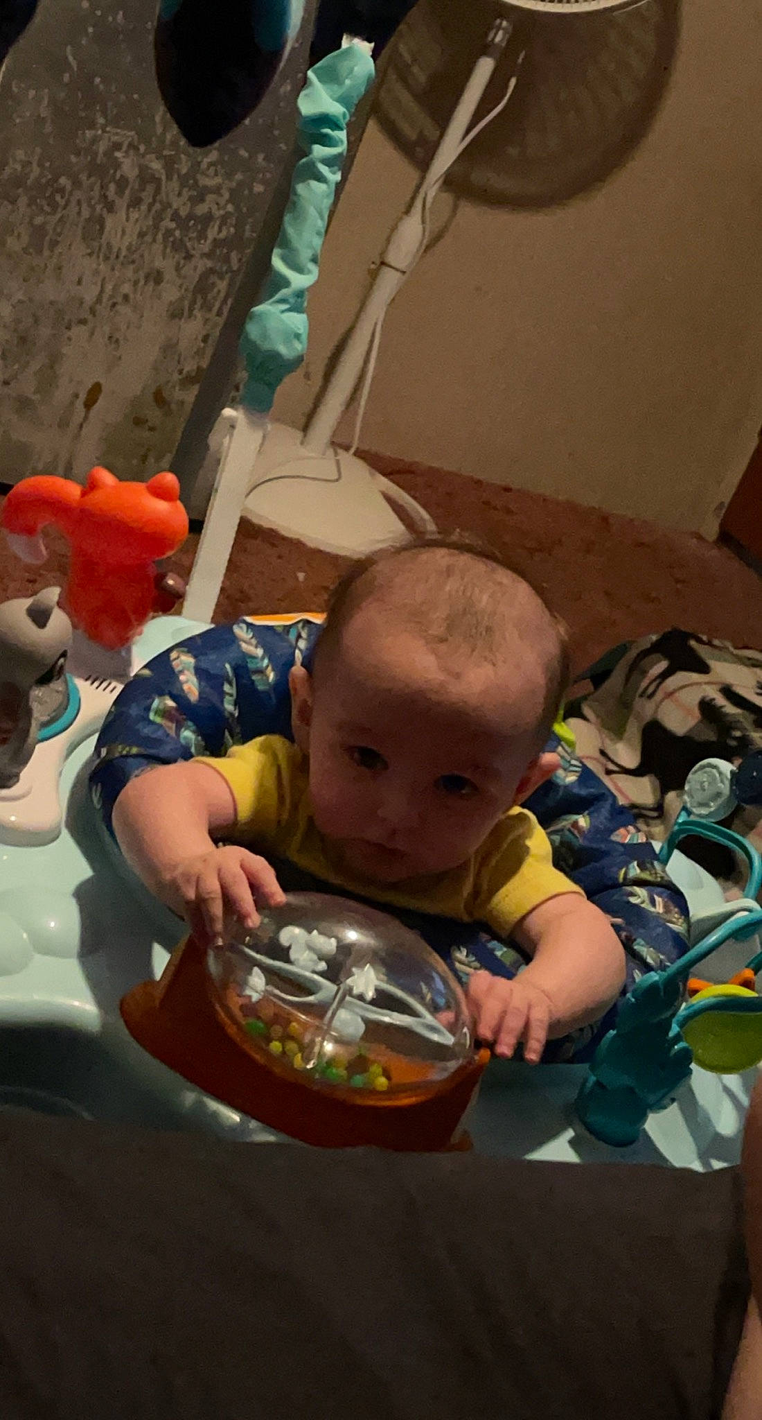 Kenai is registered to the contest to win money with this photo: baby, baby_products, baby_toddler_clothing, baby_toys, bib, cheek, child, flooring, fun, leisure, mouth, person, play, room, sitting, t_shirt, toddler, toy, vacation