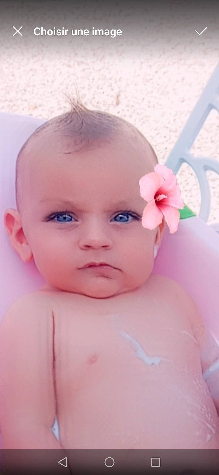 Mariana participe au concours pour gagner de l'argent avec cette photo : baby, baby_toddler_clothing, brown_hair, cheek, chest, child, chin, close_up, eyebrow, eyelash, flower, happy, lip, magenta, no_expression, nose, person, petal, pink, skin
