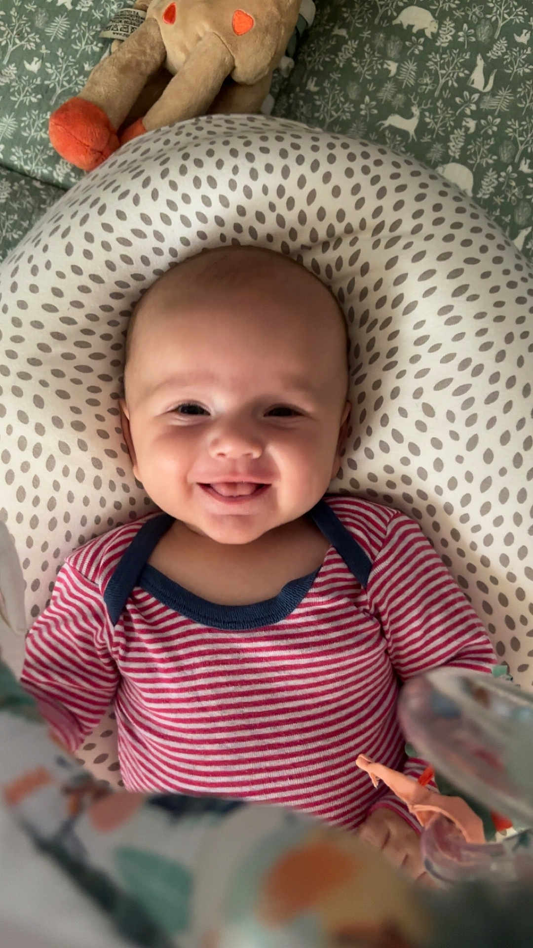 Joany a rejoint le concours — aidez-le/la à gagner de superbes lots ! baby, smiling, infant, onesie, striped_clothing, pillow, plush_toy, bed, bedding, face, tongue_out, happy, cute, child, person, indoors, closeup, head, soft_toys, patterned_fabric