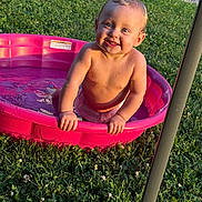 Dakota joined the competition — help win amazing prizes! toddler, child, pool, water, smiling, outdoor, grass, sunlight, summer, happy, blue_eyes, play, splash, pink_pool, bare_chest, nature, daylight, cute, fun, young_child