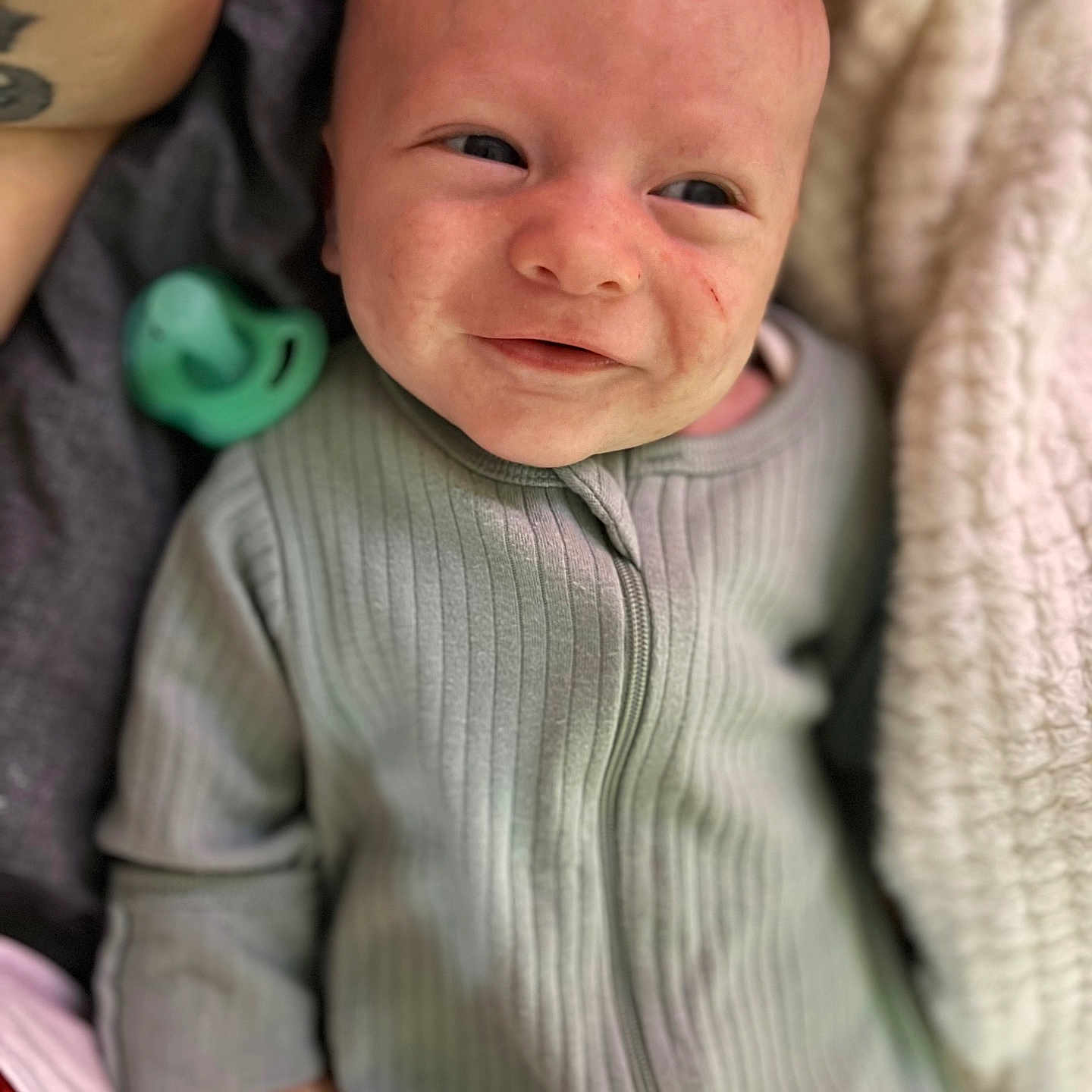 Atticus is registered to the contest to win money with this photo: baby, babylaughing, blanket, clothing, face, happy, head, knitwear, newborn, person, photography, portrait, quilt, smile, sweater