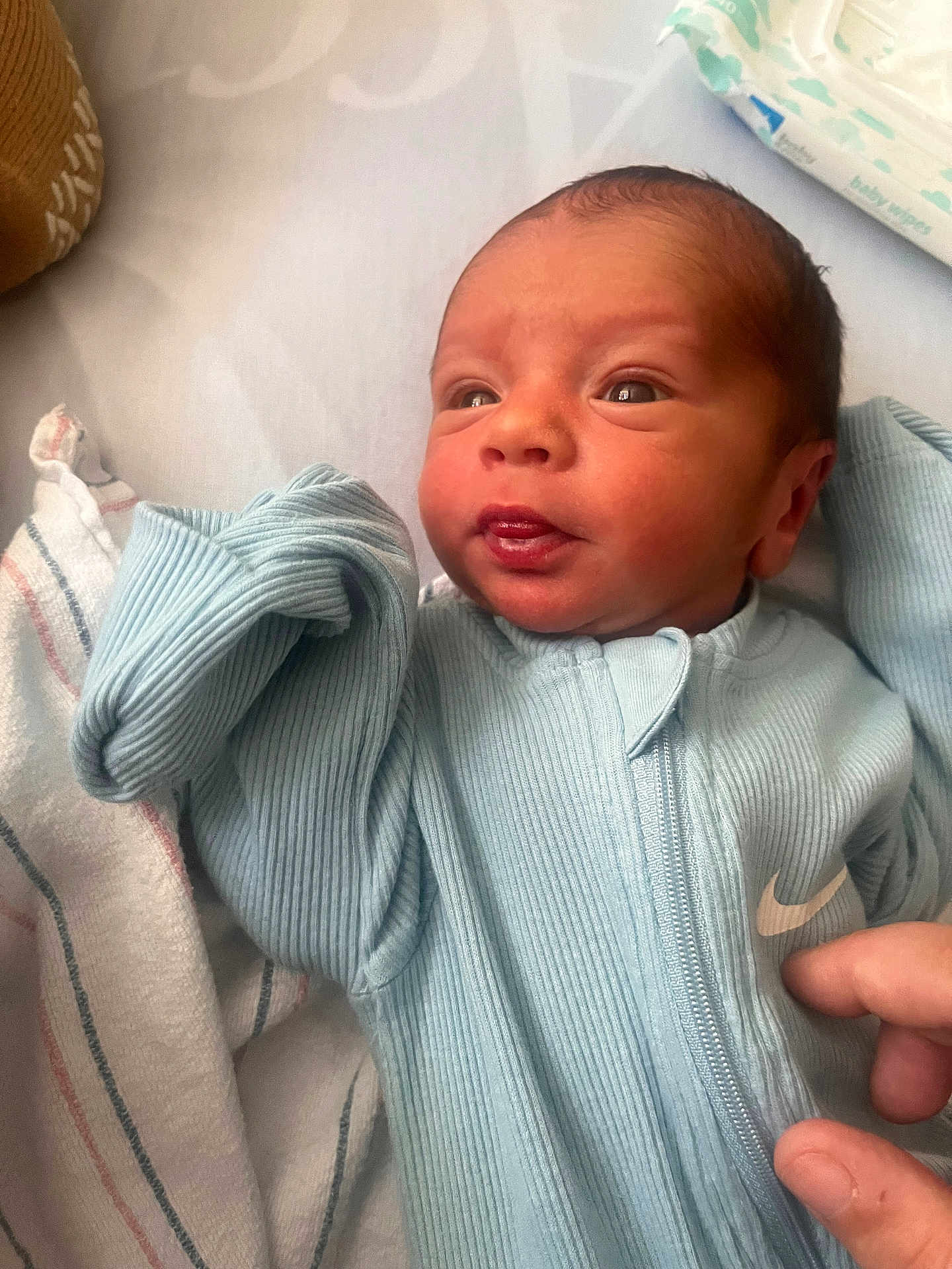 Corbin joined the competition — help win amazing prizes! newborn, baby, infant, blue_onesie, face, hand, blanket, baby_wipes, sleepwear, zipped_clothing, newborn_baby, human, skin, portrait, cute, small, indoors, resting, comfort, soft_textile