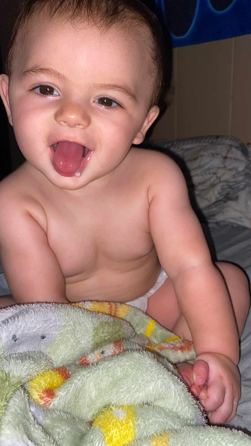 Levi is registered to the contest to win money with this photo: baby, child, tongue, drool, blanket, diaper, skin, smile, happy, face, hand, bed, indoor, cute, infant, expression, person, young, closeup, comfort