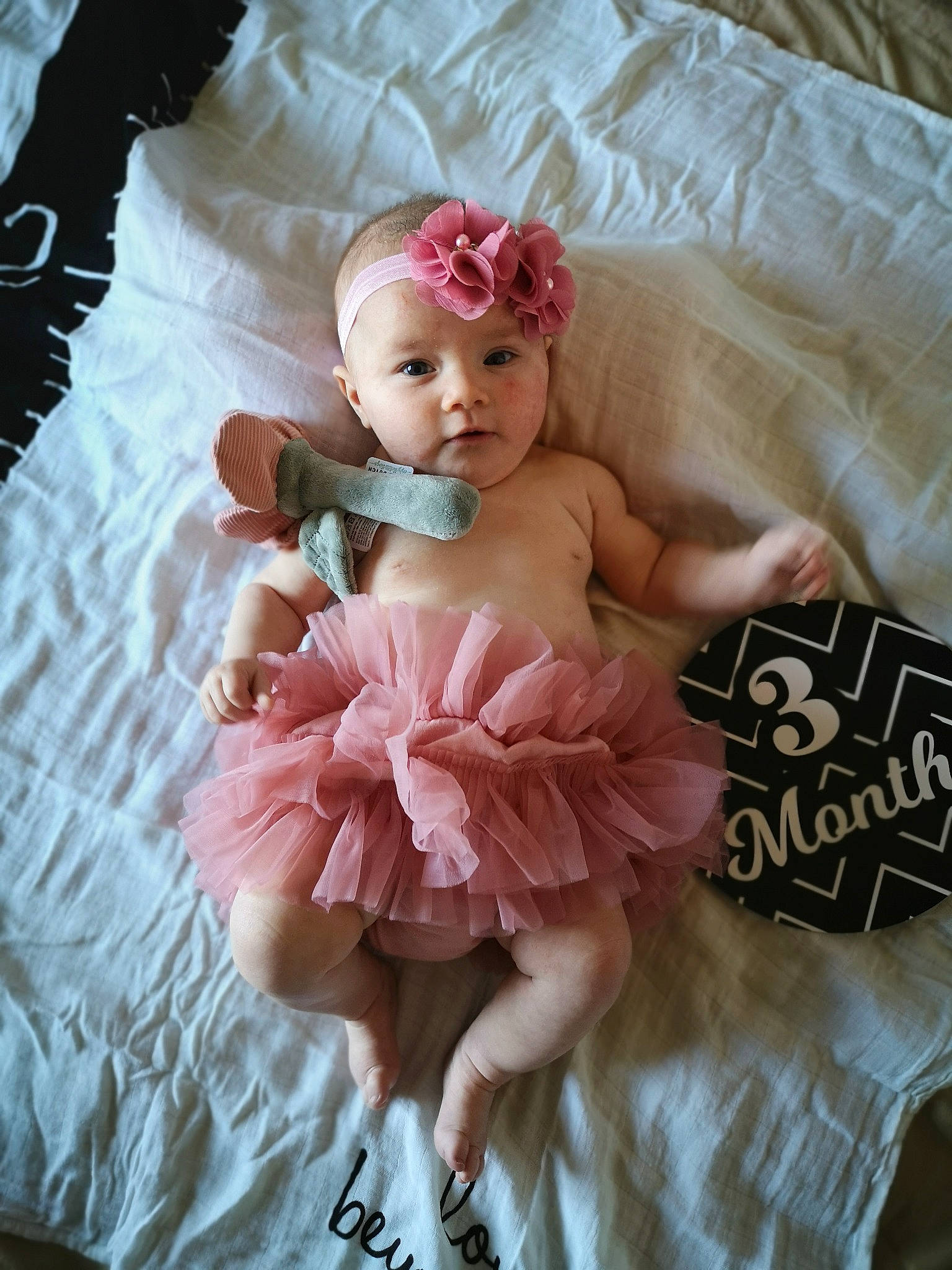 Liséa a rejoint le concours — aidez-le/la à gagner de superbes lots ! baby, baby_products, baby_toddler_clothing, ballet_tutu, bridal_accessory, child, comfort, fashion_accessory, flower, hair_accessory, headpiece, linens, magenta, peach, person, petal, pink, ruffle, textile, toddler