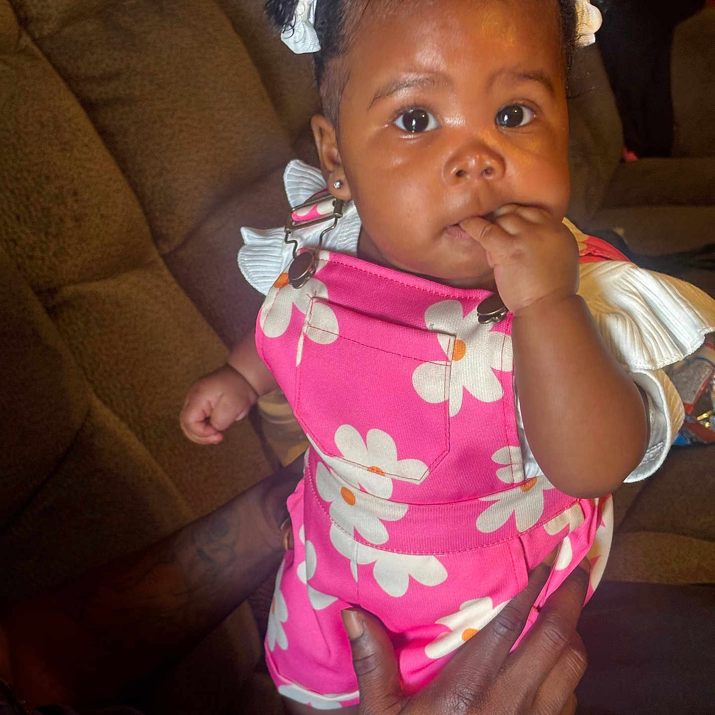 Zehlani is registered to the contest to win money with this photo: baby, child, infant, pink_clothing, hair_bows, sitting, hand, couch, indoor, person, cute, portrait, bright_eyes, small_hands, expression, holding, fingers_in_mouth, colorful_outfit, adorable, young