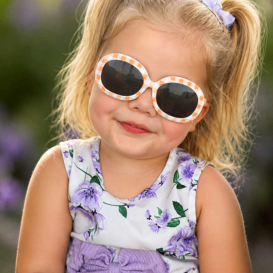 Kinlee is registered to the contest to win money with this photo: child, girl, portrait, outdoor, garden, sunglasses, floral_dress, purple, hair_bows, blonde_hair, smiling, fashion, fashionable, sunlight, bokeh, close_up, sitting, toddler, face, photography