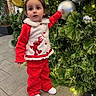 child, toddler, girl, christmas, christmas_tree, ornament, reindeer, red_outfit, festive, holiday, portrait, standing, indoors, decoration, evergreen, bauble, silver_ornament, warm_lighting, smiling, family_friendly