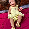 Jazlynn joined the competition — help win amazing prizes! baby, infant, child, portrait, lying_down, yellow_dress, sandals, hair_bow, smiling, face, indoors, bed, bedspread, cushion, textile, pink, magenta, fashion, sitting, photography