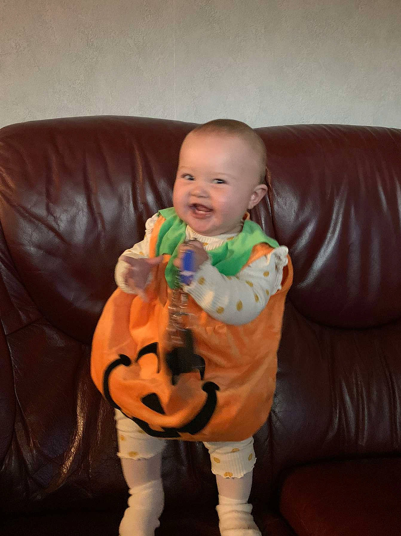 Haïlidjey a rejoint le concours — aidez-le/la à gagner de superbes lots ! baby, baby_toddler_clothing, comfort, couch, eye, finger, flooring, guitar, happy, head, musical_instrument, orange, person, sitting, sleeve, smile, string_instrument, thumb, toddler, toy