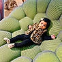 baby, child, infant, furniture, chair, green, plush, texture, leopard_print, vest, socks, black_clothing, bow, cute, indoor, floor, wooden_floor, person, portrait, relaxing