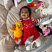 Anjena a rejoint le concours — aidez-le/la à gagner de superbes lots ! baby, child, plush_toy, stuffed_animal, giraffe_toy, polar_bear_toy, minnie_mouse_toy, yellow_chick_toy, play_mat, red_dress, white_tights, smiling, happy, indoors, cute, infant, headband, toy_ring, soft_toys, childhood