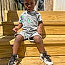 toddler, child, boy, overalls, dinosaur, shirt, sneakers, shoes, wooden_steps, outdoor, daylight, sunlight, casual_clothing, portrait, expression, person, young_child, fashion, summer, seated