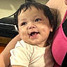 adult, baby, being_held, brown_eyes, candid, child, close_up, dark_hair, face, happy, home, indoor, infant, laughing, photography, pink_seat, portrait, sitting, smiling, white_shirt