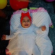 Ibtisam Mohammed a rejoint le concours — aidez-le/la à gagner de superbes lots ! baby, infant, child, smile, headband, red_bow, white_dress, tights, pillow, blanket, balloon, carpet, indoors, portrait, happy, lying_down, face, cute, party, arm