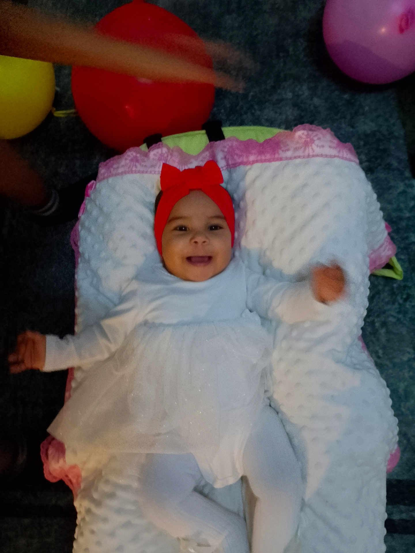 Ibtisam Mohammed a rejoint le concours — aidez-le/la à gagner de superbes lots ! baby, infant, child, smile, headband, red_bow, white_dress, tights, pillow, blanket, balloon, carpet, indoors, portrait, happy, lying_down, face, cute, party, arm