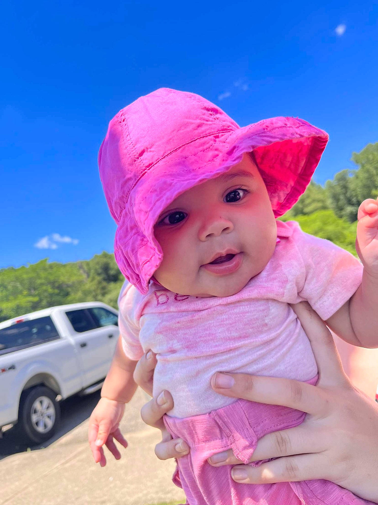 Kahlanï joined the competition — help win amazing prizes! baby, baby_toddler_clothing, cap, car, grass, hand, happy, hat, headgear, headwear, leisure, lip, magenta, person, pink, skin, sky, sun_hat, tire, toddler