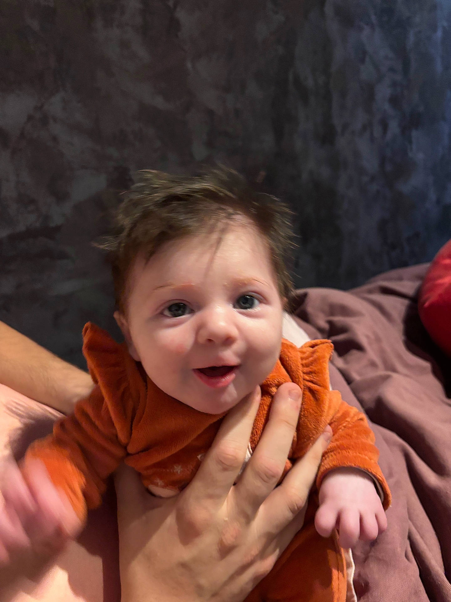 Céleste a rejoint le concours — aidez-le/la à gagner de superbes lots ! baby, child, cozy, cute, expression, face, hand, happy, human, indoor, infant, orange_clothing, person, portrait, sitting, skin, smiling, toddler, warm_clothing, young