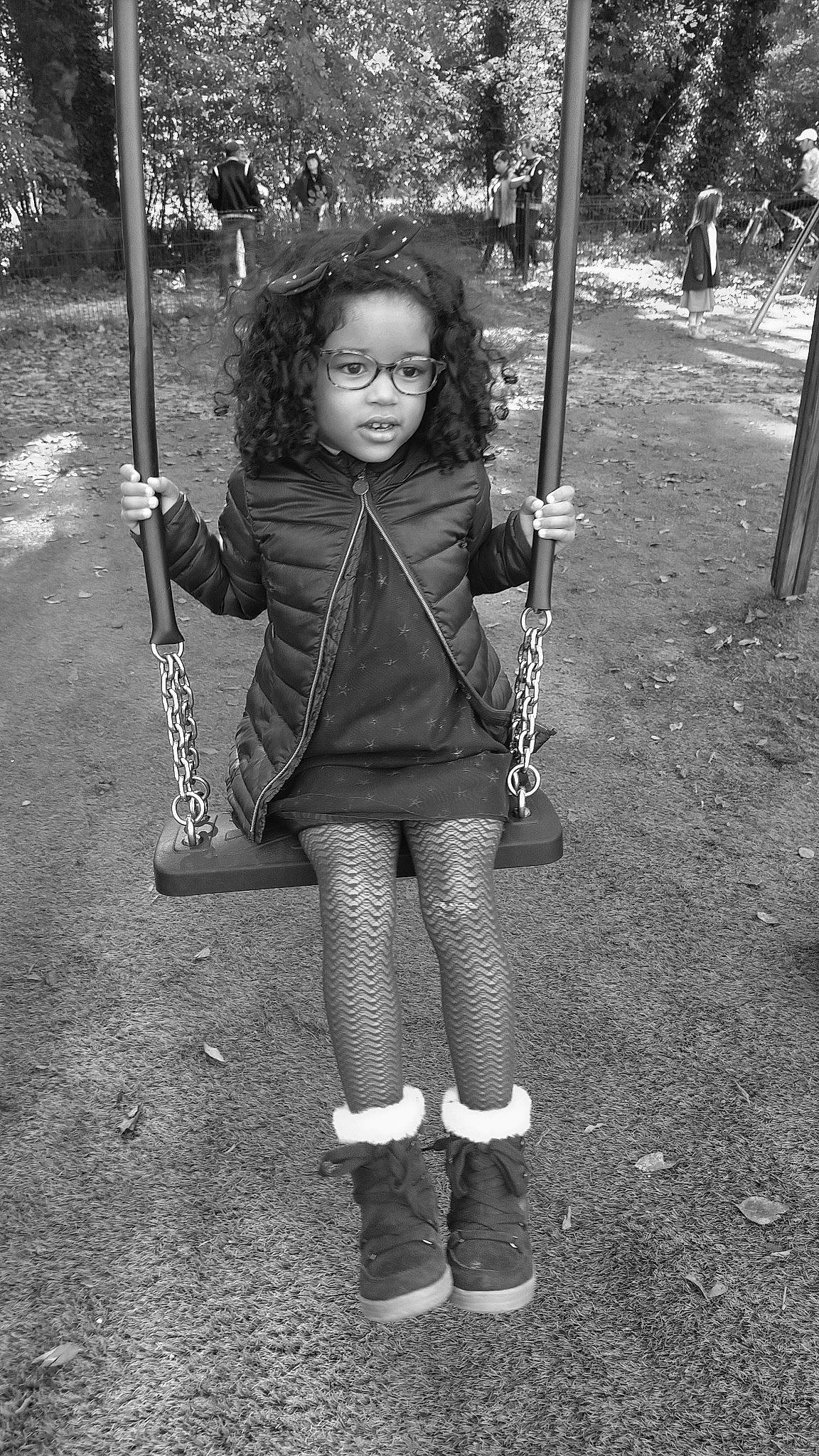 Naomi participe au concours pour gagner de l'argent avec cette photo : black, black_and_white, child, city, fun, grass, hairstyle, monochrome, monochrome_photography, outdoor_play_equipment, person, photograph, plant, playground, recreation, standing, style, swing, toddler, tree